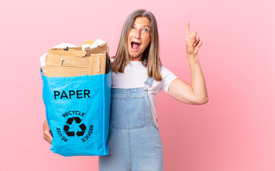 pretty middle age woman feeling like a happy and excited genius after realizing an idea recycling...
