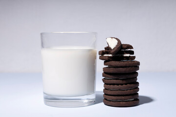 Closeup of glass of milk and stack of brown crispy chocolate on the blue table