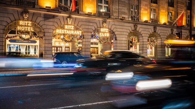 The Ritz, London. An illuminated night view of the exterior to the exclusive London hotel and restaurant with slow exposure traffic streaming by.