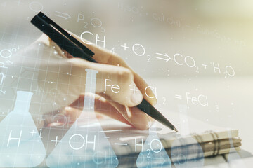 Creative chemistry concept with woman hand writing in notebook on background. Multiexposure