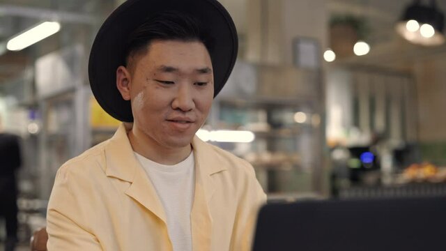 Portrait of asian man using laptop for work at cafe