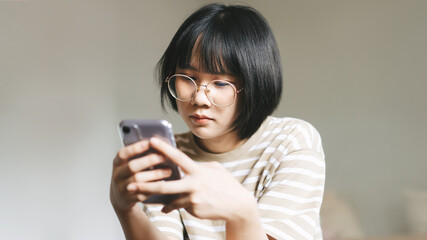 Young adult single woman using smartphone in the moring for online app mental health.