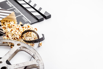 Movie reel with popcorn and clapperboard. Cinema background