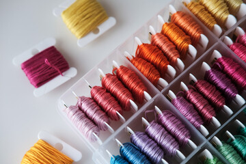 Close up of colorful embroidery floss bobbins in the box. Embroidery threads for handmade, crafts,...