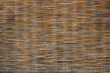 Woven bamboo or reeds hung for room partitioning or sunshade. Japanese style sunshade 'sudare' texture background
