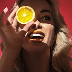 Fotobehang Portrait of young blonde woman holds slice of lemon © konradbak
