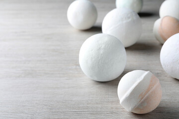 Many bath bombs on wooden table, space for text