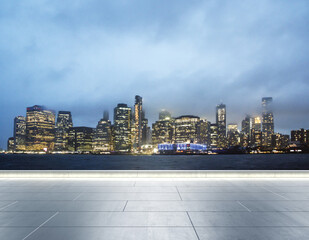 Empty concrete seafront on the background of a beautiful blurry New York city skyline at evening,...