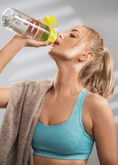 Poster Im Rahmen Portrait of sweaty blonde woman take a break after intense workout. © konradbak