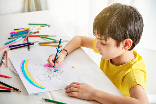 child draws his family on a piece of paper with colored pencils. Concept of child psychology.