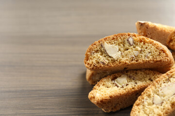 Traditional Italian almond biscuits (Cantucci) on wooden table, closeup. Space for text