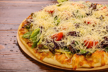 Pizza caesar with chicken, salad and cheese