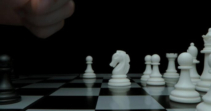 Game of chess. Filmed in a dark key. Black moves and takes the white pawn. Super macro shot of a chessboard with chess, the camera travels along the slider from white to black.