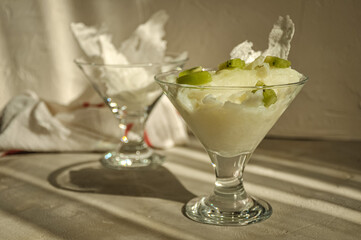 Traditional Ramadan Dessert Gullac on the table. It is made with gullac, milk, rose water, walnut, vanilla. It is decorated with kiwi.