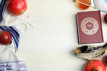 Flat lay composition with Rosh Hashanah holiday symbols on white wooden table. Space for text