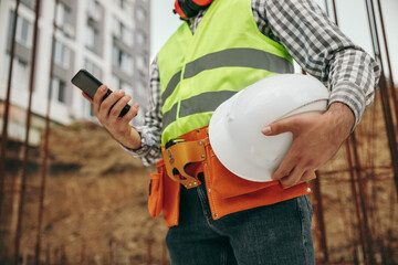 Construction technician using mobile phone on site