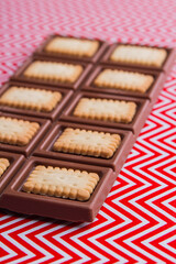 Vertical shot close-up chocolate bar with crunchy cookies.