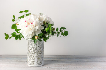 Flower arrangement with white peonies flowers in a vase on a white background