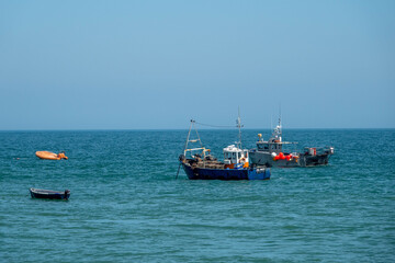 Naklejka na ściany i meble fishing trawlers at anchor in the sea on a bright spring day