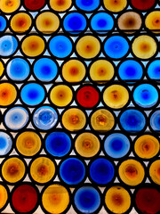 A glass window decorated in multicoloured circles.