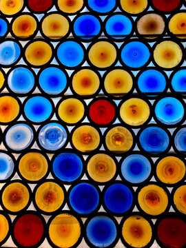 A glass window decorated in multicoloured circles.