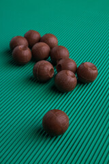Vertical shot round chocolate candies on green background.