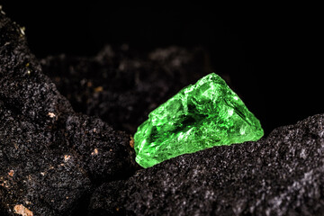 raw emerald gem in rare stone mine, bright green stone