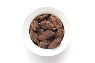 Macro close-up of Organic Black cardamom (Amomum subulatum)  on white background. Pile of Indian Aromatic Spice. Top view