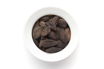 Macro close-up of Organic Myrobalan or harad (Terminalia chebula) on white background. Pile of Indian Aromatic Spice. Top view