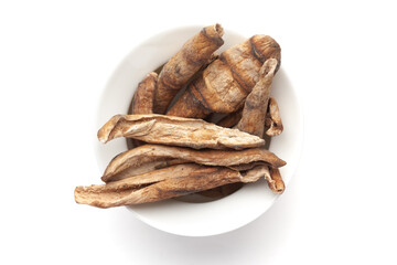 Macro close-up of Organic dried mango slices (Mangifera indica) or amchoor on white background. Pile of Indian Aromatic Spice. Top view