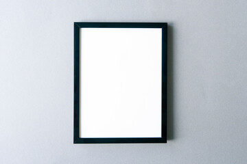 Frame mockup, black photo frame with blank surface on gray wall. Space for text.