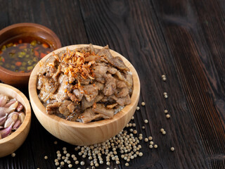 Thai food, Rice topped with pork and garlice in wooden bowl on brown wooden table. Favorite food in Thailand.