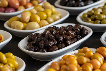 Assortment of olives on the plate in bulk. Organic black olives, Olive varieties
