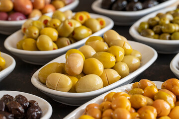 Assortment of olives on the plate in bulk. Organic black olives, Olive varieties