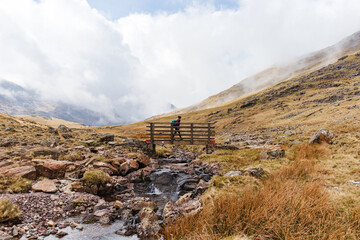 girl hiking over bridge