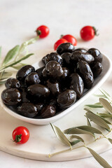 Black kalamata olives. Tasty organic kalamata olives in the plate. Olive on marble floor