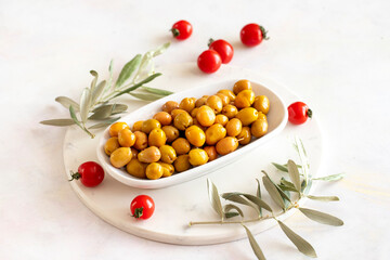 Scratched yellow olives. Tasty organic yellow olives in the plate. Olive on marble floor