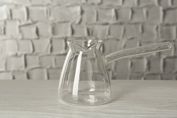Glass turkish coffee pot on white wooden table