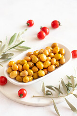 Scratched yellow olives. Tasty organic yellow olives in the plate. Olive on marble floor