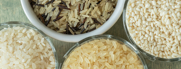 banner with top view close up different types of rice. wild rice, sushi rice, shredded and steamed rice on a green wooden background. healthy food concept.