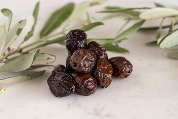 Close-up black olives. Organic olives on a marble floor