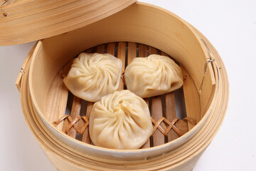 Xiao long bao dim sum dumpling chicken prawn fish seafood vegetable in bamboo steamer on white...
