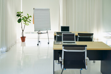 Empty seminar trainging room with flip chart and education desk and laptop