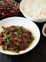 Thai food, Stir fried meat and basil in white plate on brown wooden table. Favorite food in Thailand.