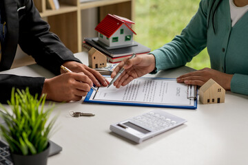 Close up house model with business man working at office,signs a purchase contract or mortgage for...