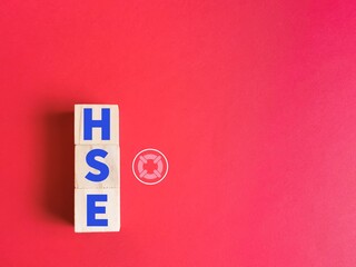 Health and Safety Executive with icon concept. HSE alphabet on wooden cubes isolated on red background.
