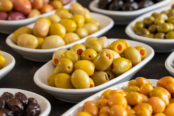 Assortment of olives on the plate in bulk. Organic black olives, Olive varieties