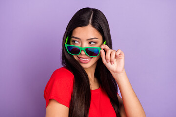 Photo of sweet millennial brunette hairdo lady look empty space wear spectacles red t-shirt isolated on violet color background