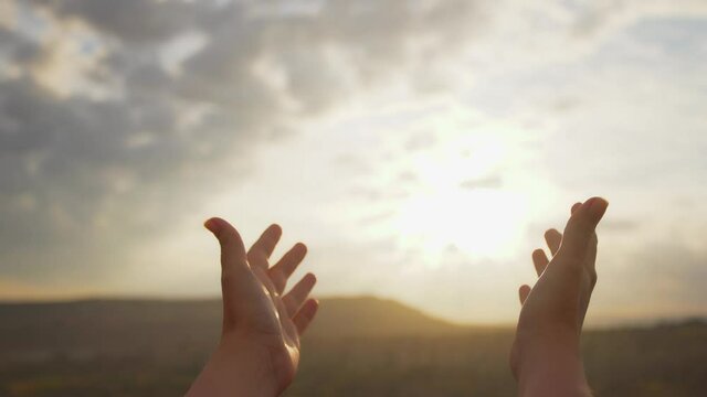 Close-up view 4k stock footage of 2 open hands raised to sun in worship. Woman asks help, advise  or blessing of God. Christian concept video background