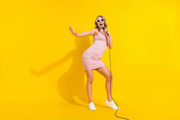 Fototapeta na wymiar Full body photo of funny blond hairdo young lady sing in mic wear pink dress isolated on bright yellow color background